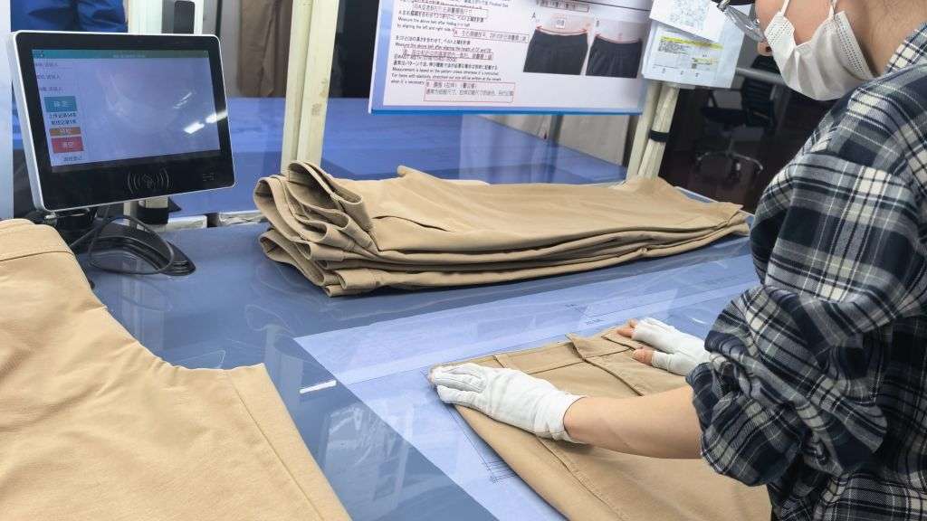 Quality control inspector checking garment measurements against specifications at Newasia Garment