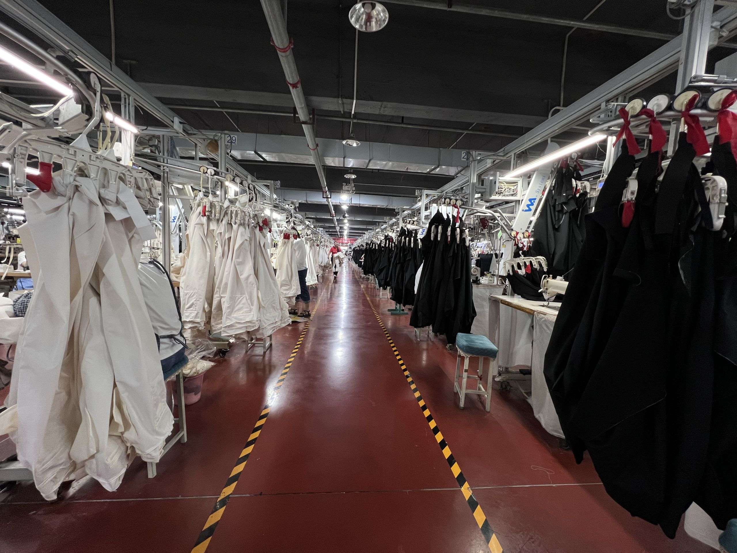 Skilled garment workers sewing denim apparel with standardized production methods