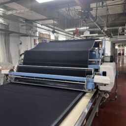 Denim fabric inspection checking color shade texture weight and material consistency before production