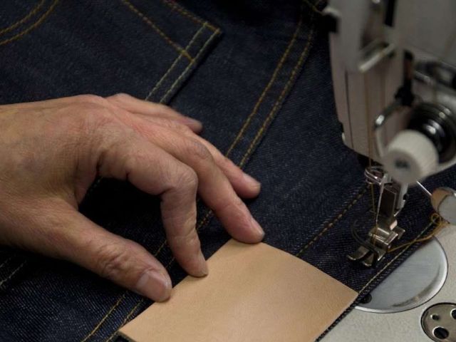 Skilled workers sewing denim skirts with reinforced stitching and quality craftsmanship