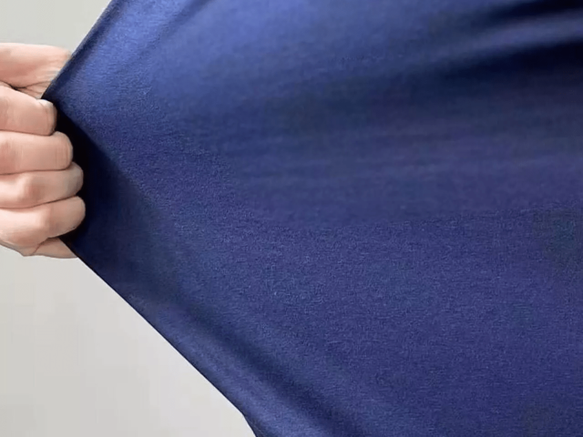 Close-up of heavyweight cotton jersey fabric showing dense knit texture and premium hand feel