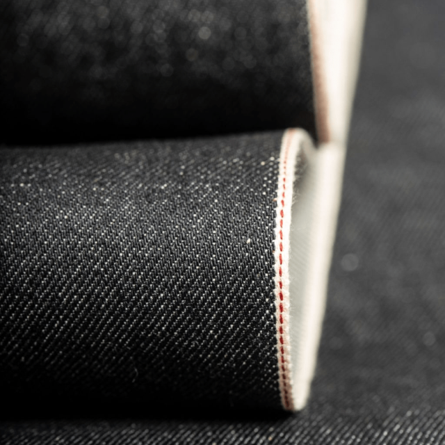 Close-up of raw selvedge denim fabric edge showing authentic selvedge weave line