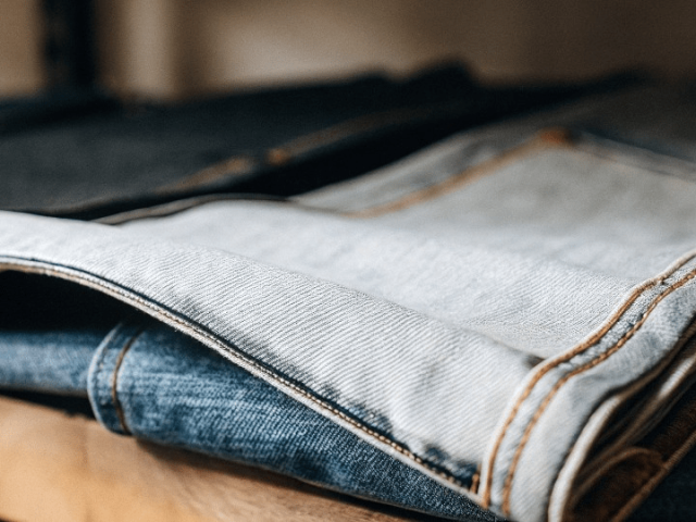 Clean and reinforced chain stitching on the inseam of premium raw denim jeans showcasing expert apparel manufacturing