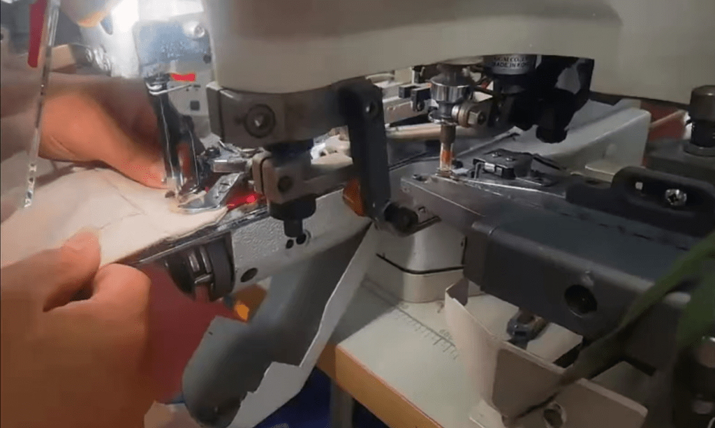 Close-up of reinforced denim stitching around a hardware attachment point