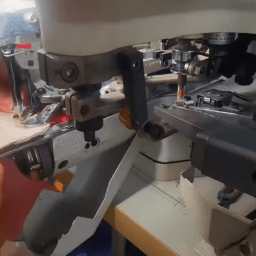 Close-up of reinforced denim stitching around a hardware attachment point