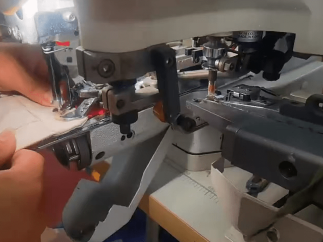 Close-up of reinforced denim stitching around a hardware attachment point